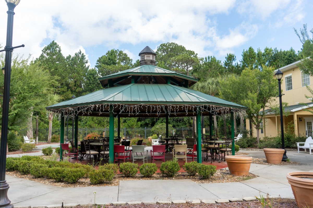A charming gazebo set in a lush outdoor park, surrounded by greenery.