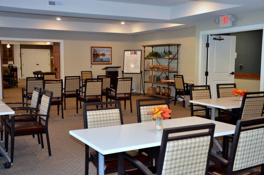 An empty meeting room with arranged tables and chairs.