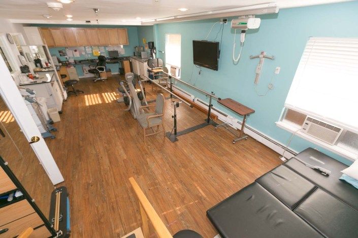 A physical therapy room equipped with various exercise and rehabilitation equipment.