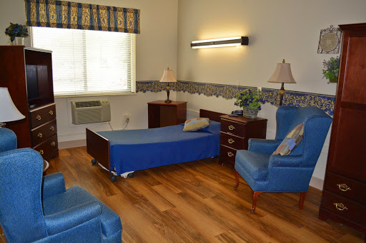 A cozy room featuring blue seating, wooden flooring, and a warm atmosphere.