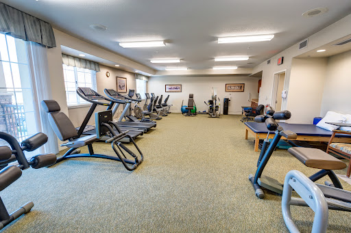 A spacious fitness center equipped with various exercise machines and weights.