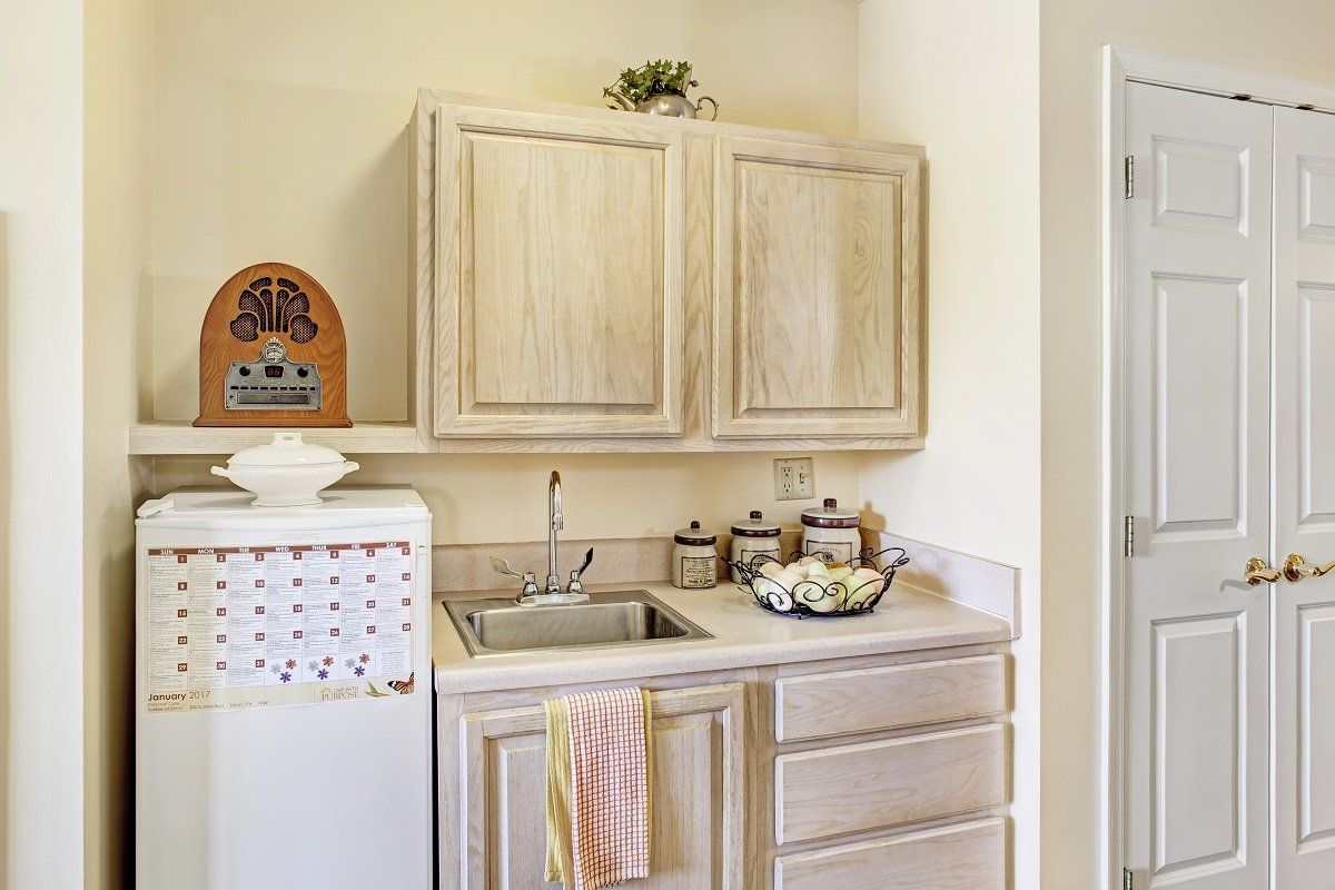 A cozy kitchen corner featuring wooden cabinets, a vintage radio, and ceramic jars on the countertop.