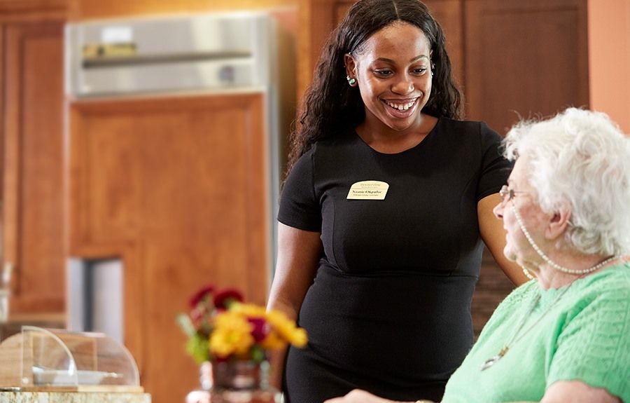 A caregiver interacting with an elderly person in a supportive environment.
