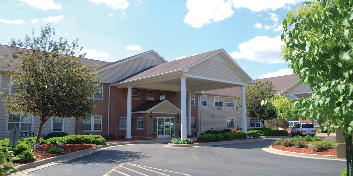 An exterior view of a building with a covered entrance and columns.