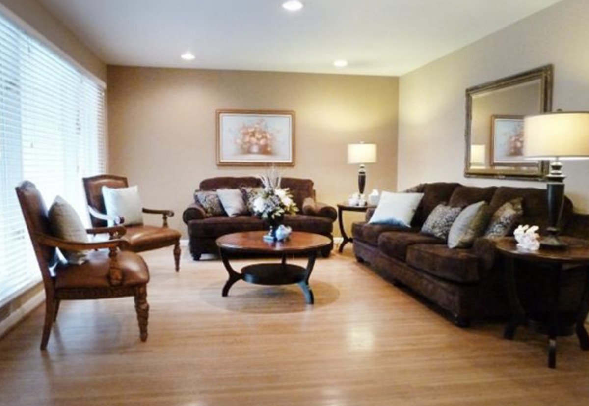 A cozy living room with brown sofas and a round wooden coffee table.