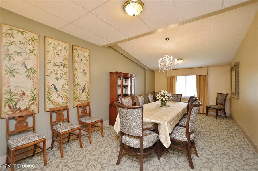 Elegant dining room with a large table, chairs, and decorative artwork.