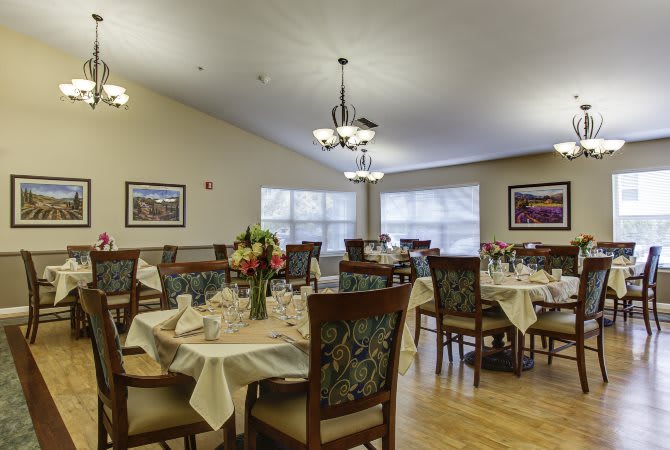 A well-decorated dining room with elegantly set tables and chairs.