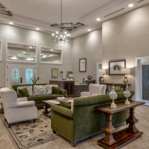 A spacious living room with elegant furniture and a chandelier.