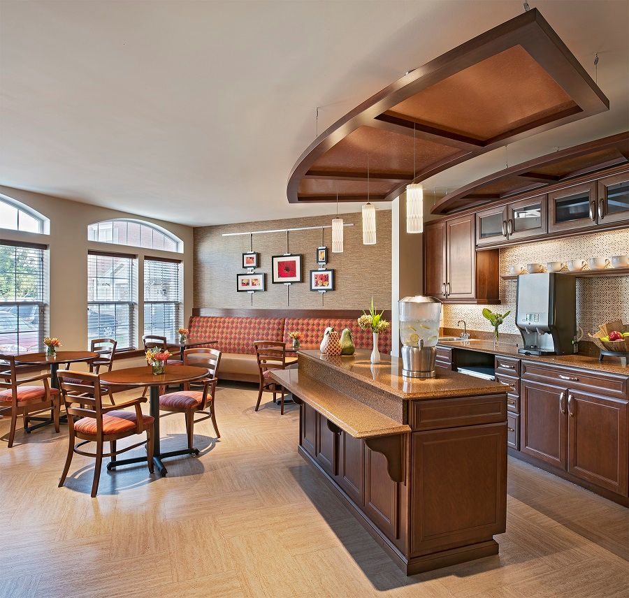 A modern kitchen and cafe area with wooden furniture and a seating space.
