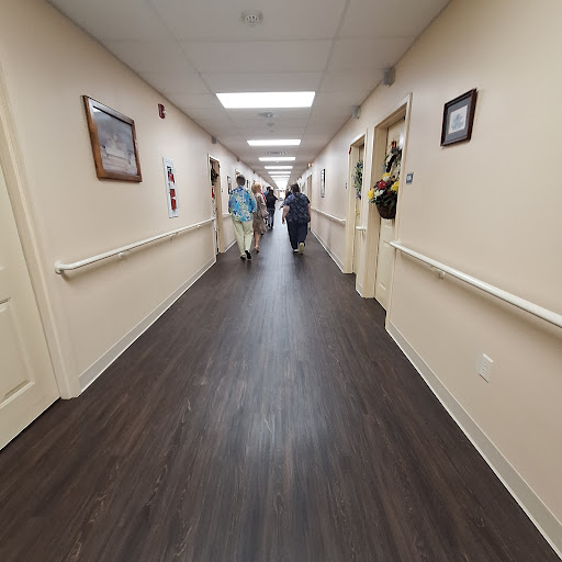 A wide view of a well-lit hallway in a healthcare facility with people walking.