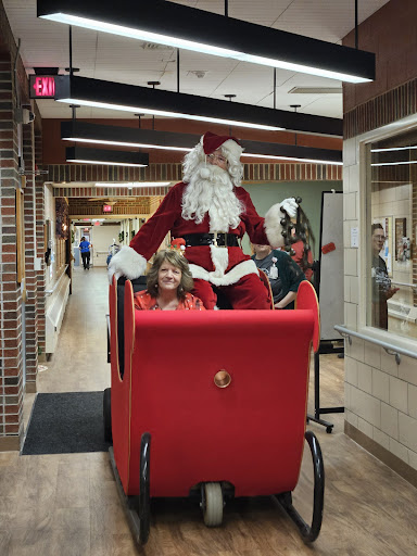 Santa Claus spreads holiday cheer while riding in a sleigh with delighted children.