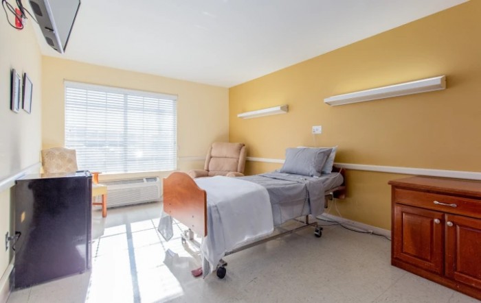 A modern hospital room with a patient bed and natural lighting.