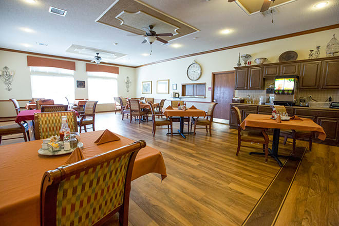 A cozy dining area with neatly set tables and warm lighting.