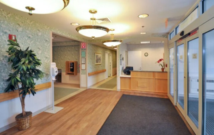 A well-lit lobby and reception area with a desk and hallway.