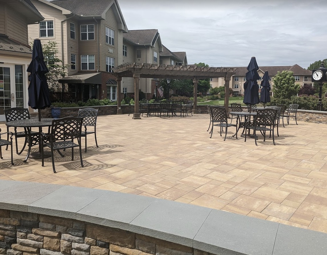 Outdoor patio area with tables and chairs near a residential building.
