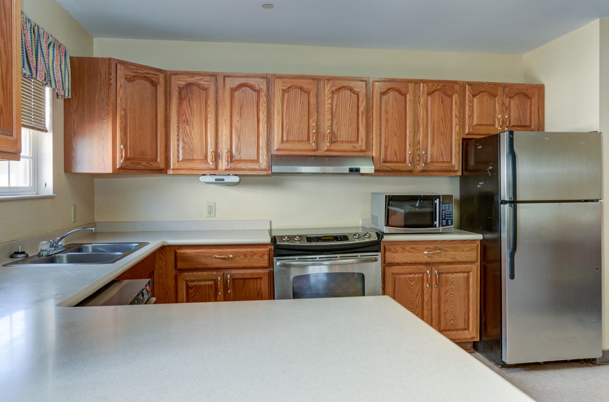 A modern kitchen featuring wooden cabinets and stainless steel appliances.