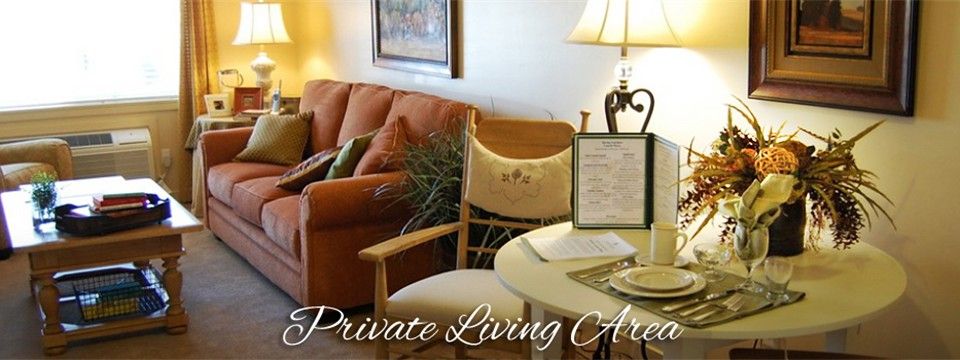 A cozy private living area with a sofa, table, and lamp.