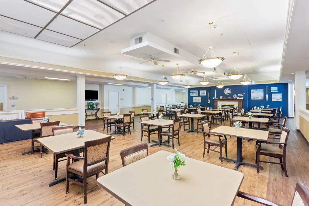 A spacious and well-lit dining area with neatly arranged tables and chairs.