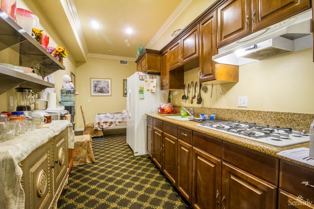 A cozy kitchen with wooden cabinets, a stove, and a refrigerator on a checkered floor.