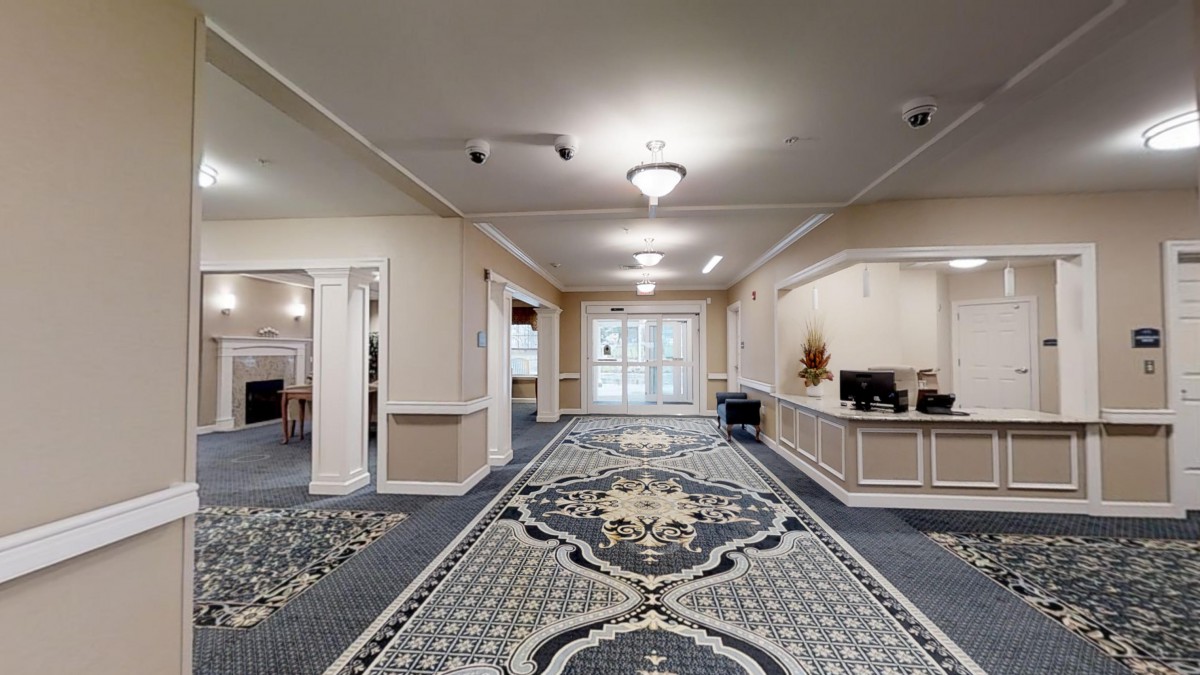 A spacious lobby with a decorative carpet and elegant lighting.