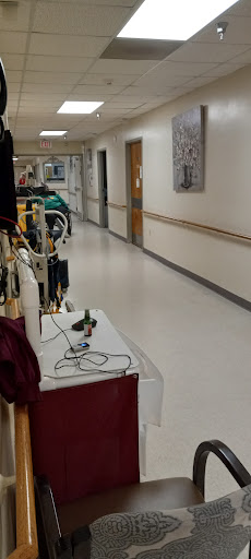 A view of a hospital corridor featuring medical equipment and a clean, well-lit environment.