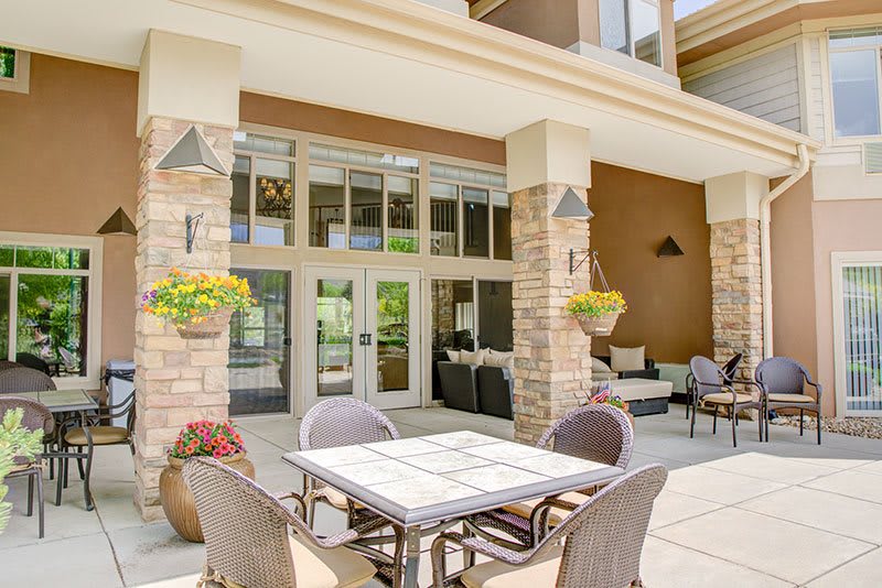 A modern outdoor patio with seating and decorative plants.