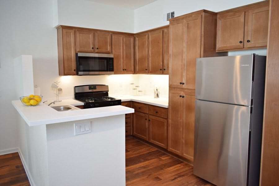 A modern kitchen with wooden cabinets and stainless steel appliances.