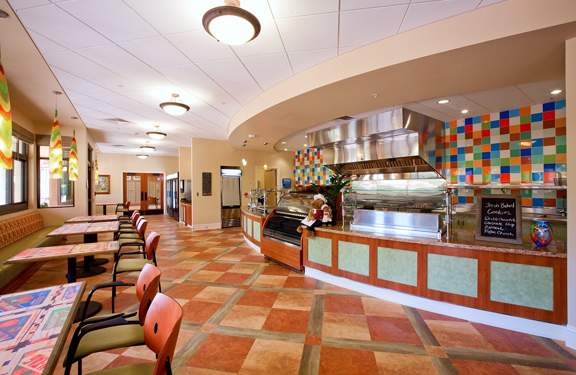 An empty restaurant interior with tiled flooring and a visible serving counter.