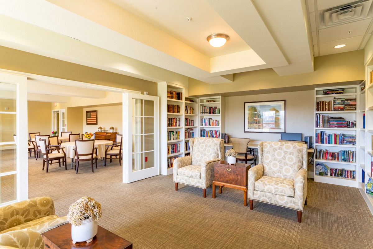 A spacious living room with comfortable seating and bookshelves.