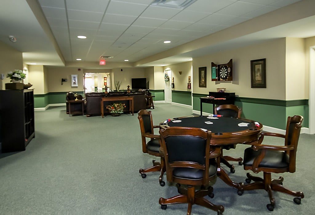 A spacious game room with tables and chairs arranged for leisure activities.