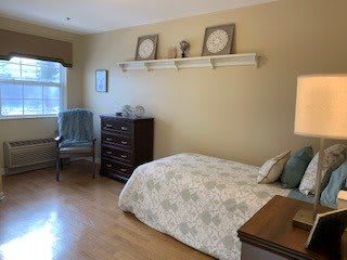 A cozy bedroom with a single bed, dresser, and decor on the shelf.