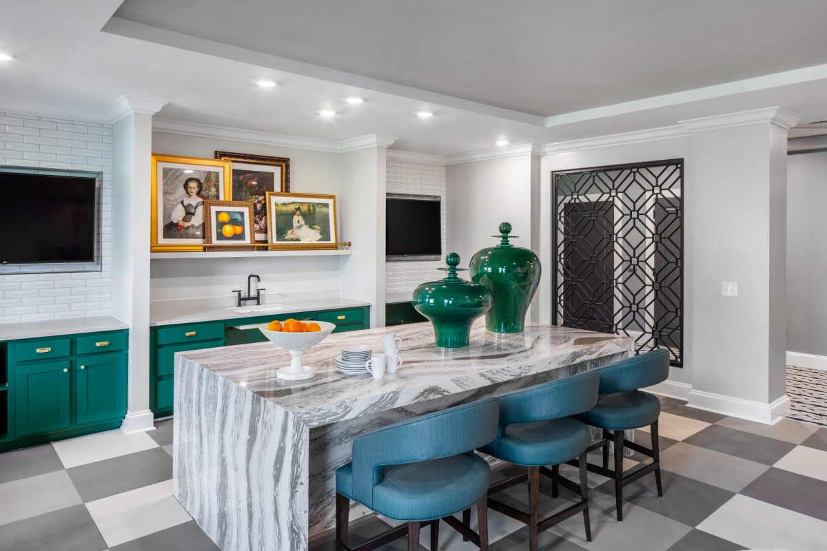 A modern dining area featuring a stylish kitchen island with bar stools and green decorative elements.