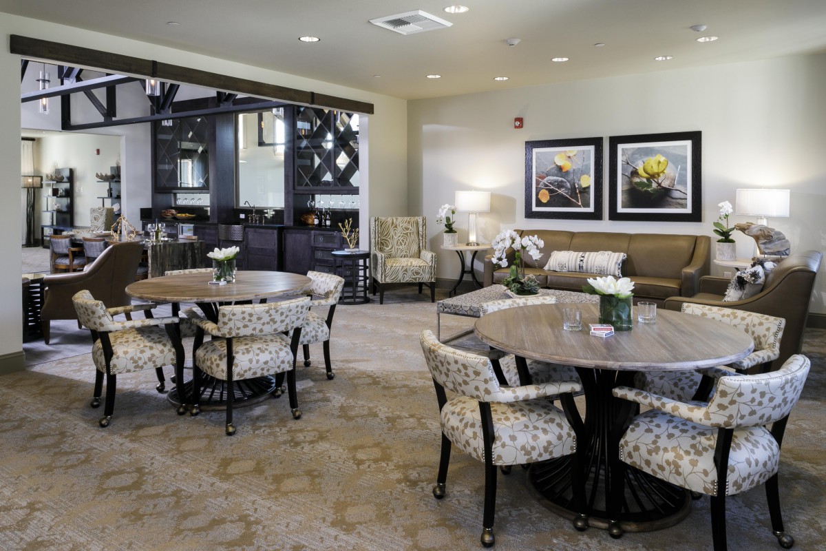 A cozy lounge area featuring elegant tables and chairs, complemented by wall art and decor.
