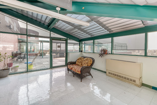 A bright and inviting sunroom featuring a comfortable sofa and large windows that allow natural light to fill the space.