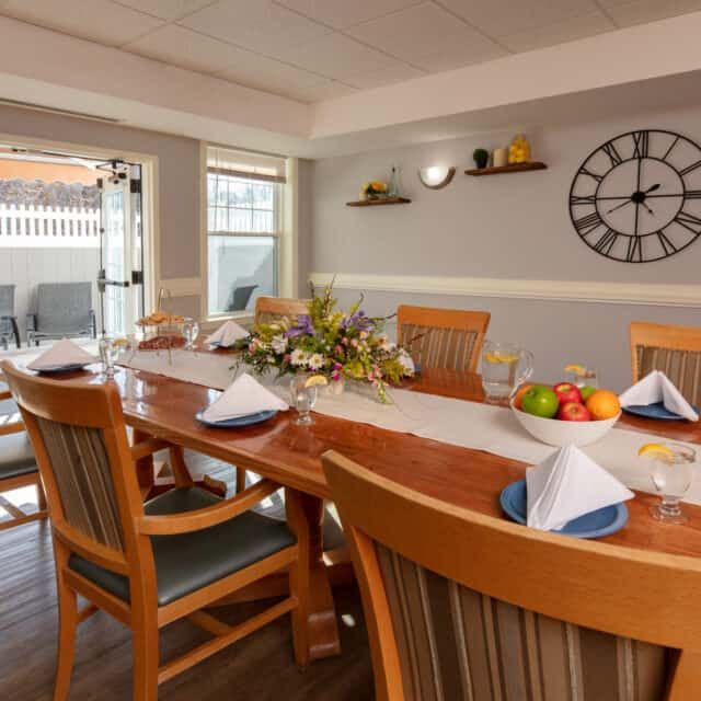 A well-set dining room table with neatly arranged place settings and a decorative centerpiece.