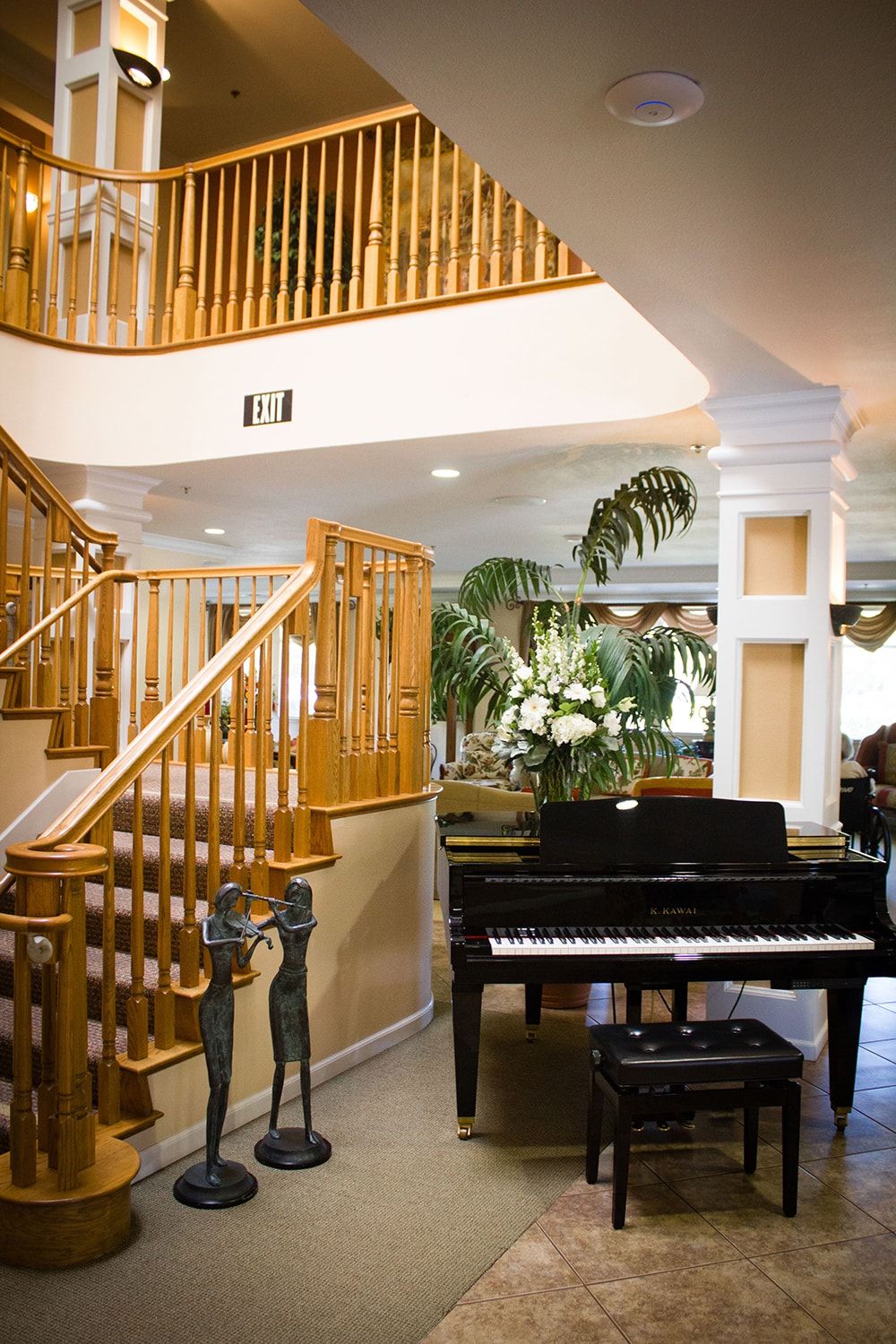 A luxurious living room featuring a grand piano and a wooden staircase.