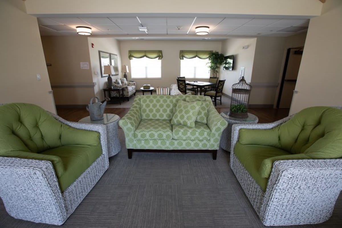 A well-lit lobby with green upholstered seating and modern decor.
