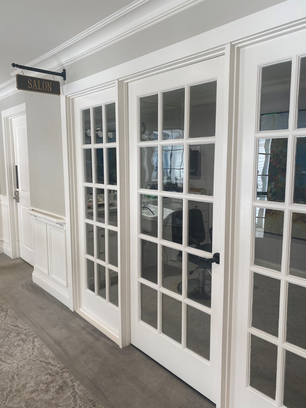 A modern office interior with glass-paneled doors leading to a conference room.