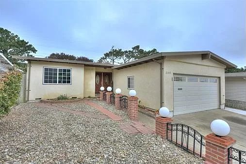 A single-story residential house with a driveway and garage entrance.