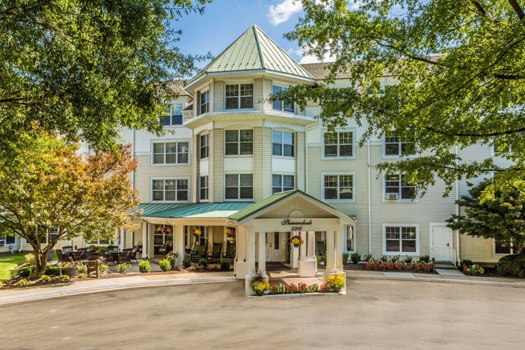 A well-maintained hotel entrance surrounded by trees.