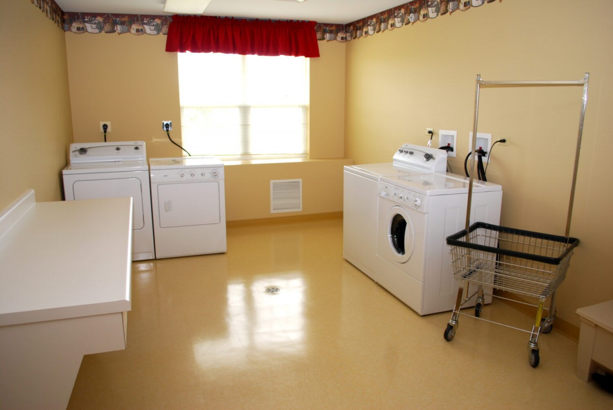 A laundry room with washing machines and a dryer.