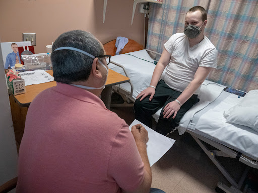 A patient speaks with a healthcare provider in a hospital setting.