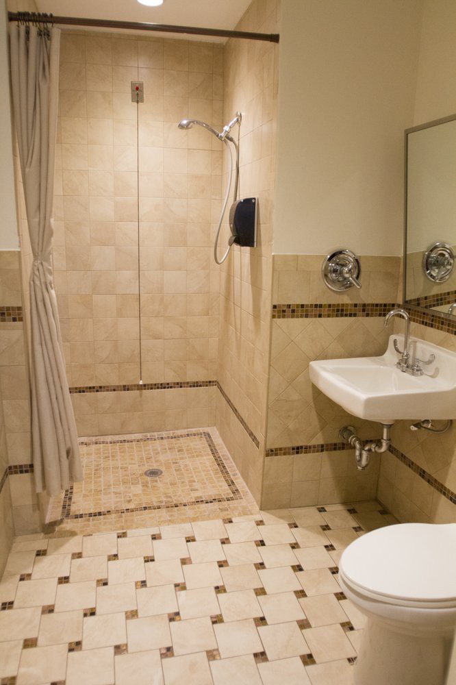 A well-designed bathroom featuring a walk-in shower, sink, and decorative tiles.