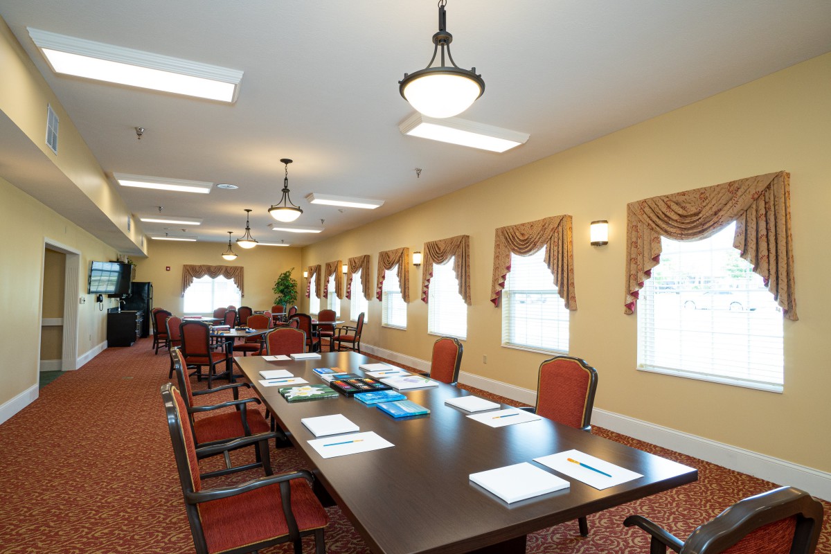 A spacious conference room with a long table and multiple chairs, set up for a meeting.