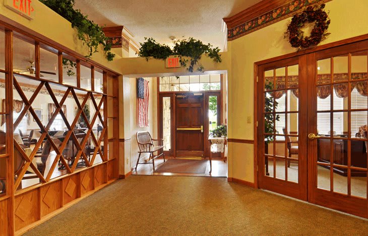 A warmly decorated interior entrance with wooden accents and greenery.