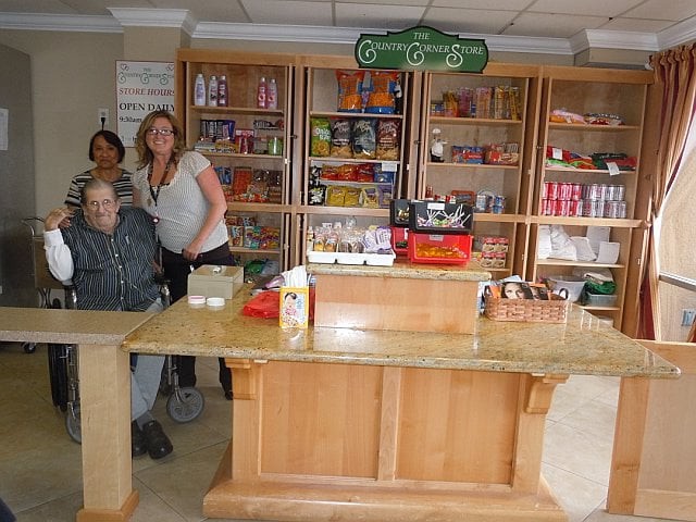 A group of people standing behind the counter of a candy shop.