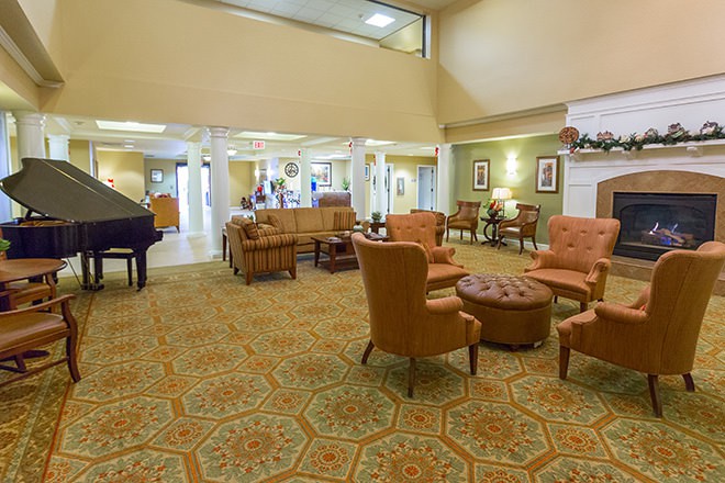 A spacious lobby with comfortable seating, a grand piano, and elegant decor.