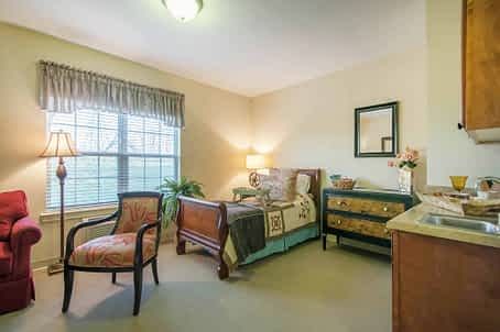 Cozy bedroom with classic furniture and a sunlit window.