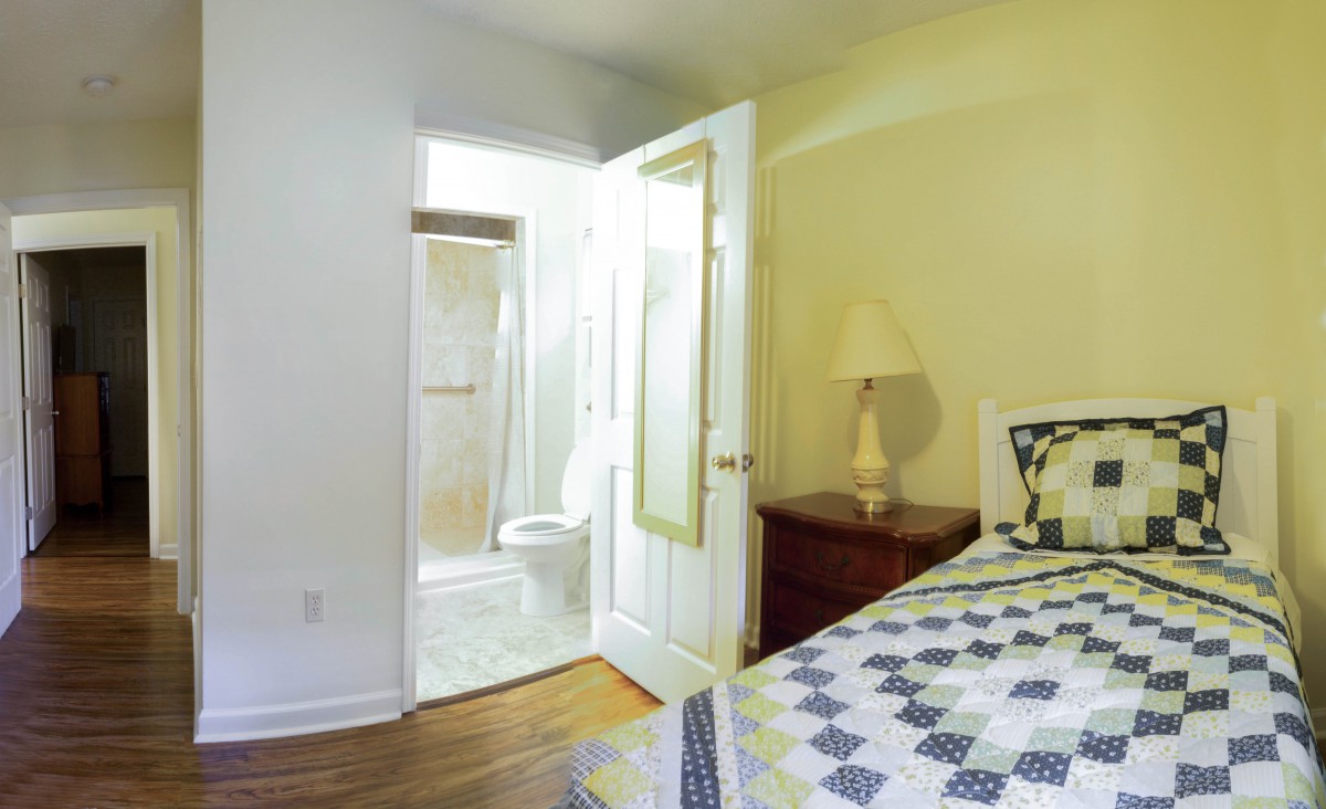 A cozy bedroom with an open door leading to a bathroom.