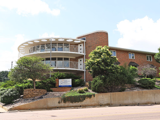 A modern residential building featuring a unique circular design with a landscaped exterior.